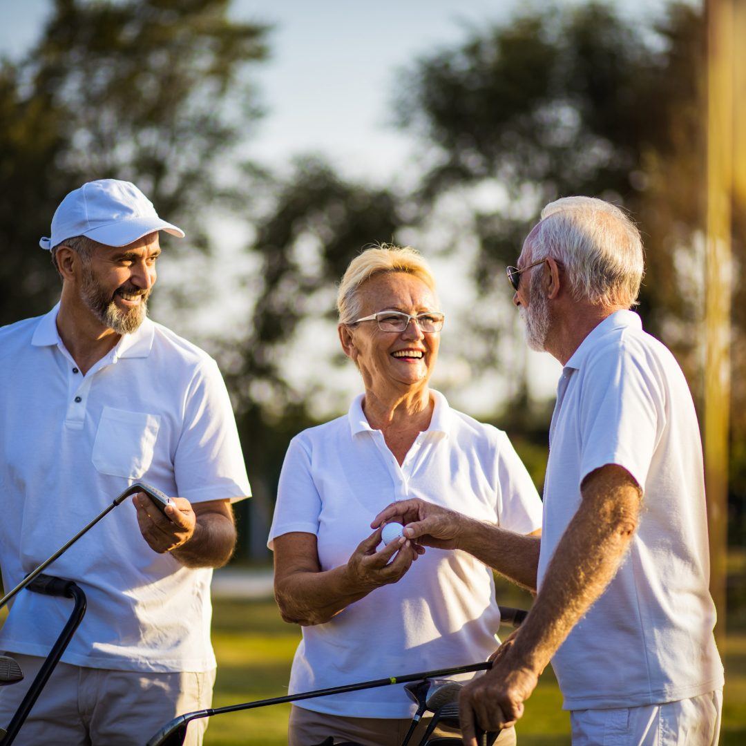 Three friends laughing together on a golf course
