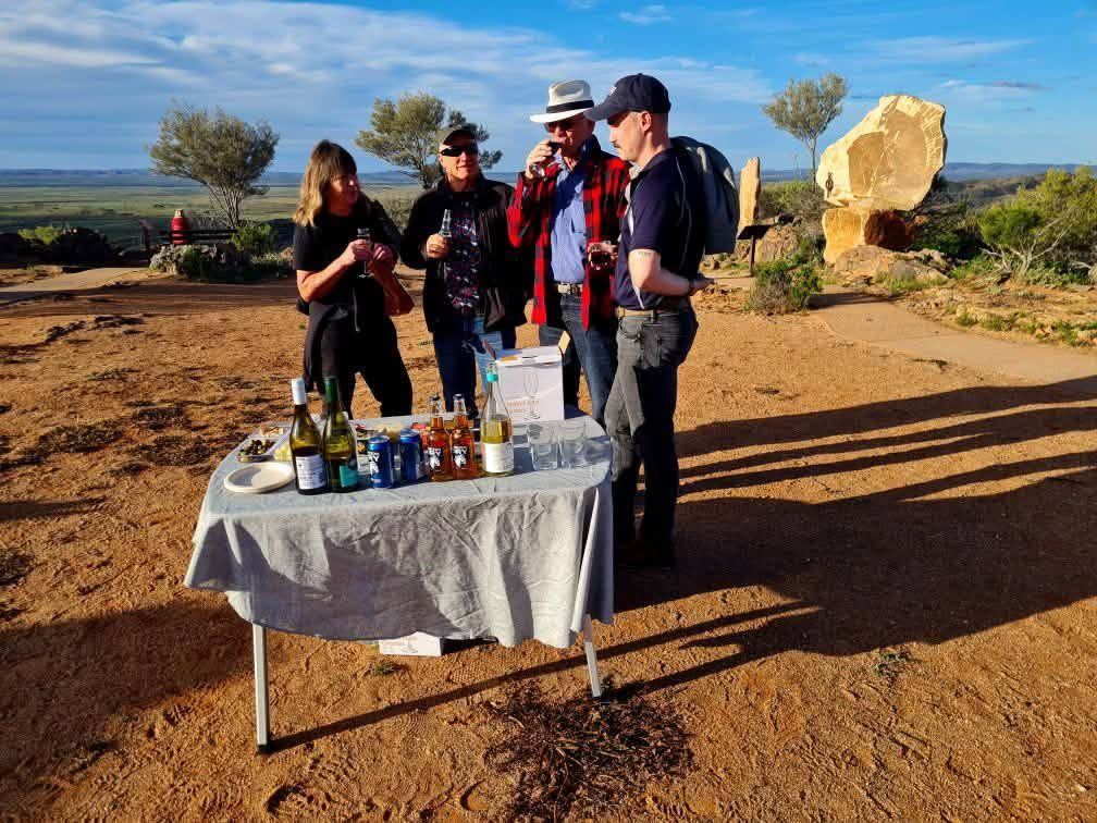 Guests with drinks beside a table of bubbles at the Living Desert Sculptures